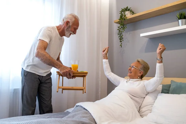 Stock image Breakfast in bed. Senior man bringing breakfast to his wife in bedroom.