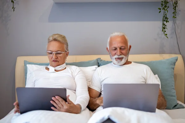 Heureux Couple Personnes Âgées Utilisant Ordinateur Portable Tout Étant Couché Images De Stock Libres De Droits