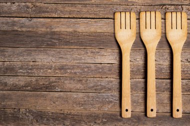 Köy ve eski ahşap çatalların arka planında bir tarafında üç tahta çatal var..