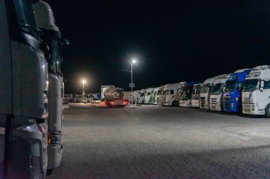 Kamu otoparkında uyuyan kamyoncular bir restoran ve yürüyüşü başlatan bir kamyonla dolu. 