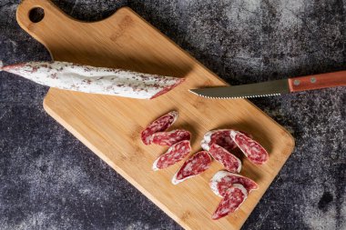 İspanya 'nın dört bir yanına yayılmış domuz eti ve domuz pastırmasına dayalı, ahşap bir kesme tahtasıyla dilimlenmiş, tipik Katalan sosisi..