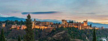 Panoramic of the Alhambra and the Palace of Carlos V with its artificial lighting at sunset.