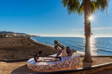 Rincon de la Victoria beach in Malaga, with a monument with ship anchors on the promenade in memory of its seafaring past.foreground.
