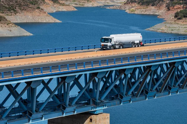Fuel tanker truck driving over a bridge .