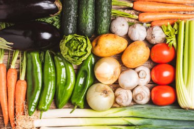 Sebze, salatalık, patlıcan, patates, biber, sarımsak, mantar, marul, havuç, pırasa, kereviz ve salatalıkla yaratılmış arka plan.