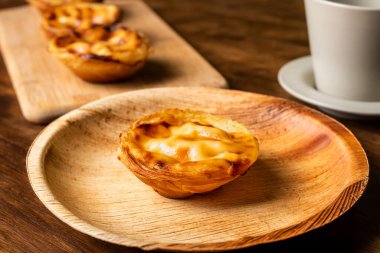 Pasteis de nata, diğer adıyla de Belem, Lizbon, Portekiz 'den tipik bir tatlı, bir fincan kahvenin yanında bir kek..