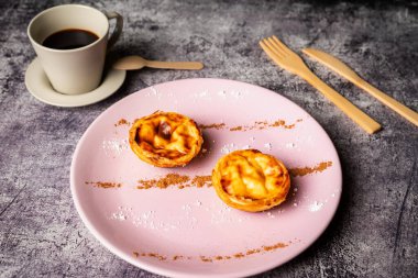 Pasteis de nata, Lizbon, Portekiz 'den tipik bir tatlı, bir fincan kahvenin yanında birkaç hamur işi..