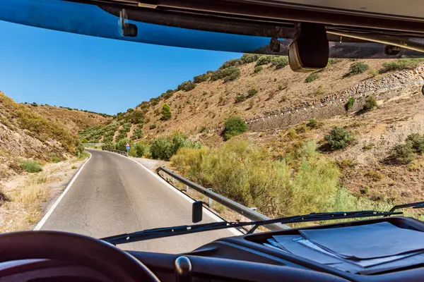 Dar bir dağ yolunun içinden, kıvrımlı ve dik bir yamacı olan bir kamyonun içine bak..