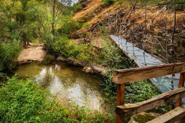 Iron suspension bridge on the Castril River, small bridge on the Castril River Gorge hiking route. clipart