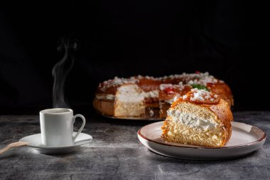 Bir dilim King 's Cake ve yanında bir fincan kahve. Üç Bilge Adam' ın ziyafetinde kullanılan tipik bir tatlı. Tatlı hamurla yapılmış, şekerli meyvelerle süslenmiş ve kremayla dolu..