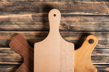 Gastronomik konsept, koyu renkli ahşap bir masa üzerindeki birkaç kesme tahtası, üst görünüm.