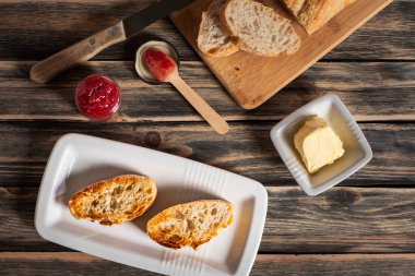 Ekmek dilimleri, tereyağı ve ahududu reçeli ile tost yapmak için gerekli malzemeler..