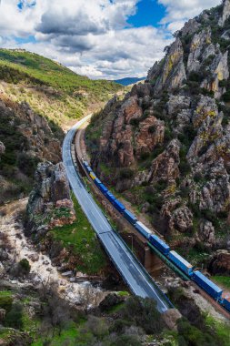 Despeaperros 'un eski yolu, Los Organos' un Doğal Anıtı, Despeaperros Doğal Parkı, Jaen, Endülüs 'ten geçen bir yük treni ile rayların yanında geçmektedir..