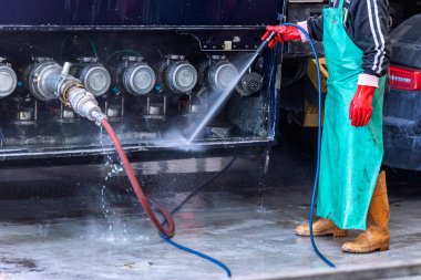 Bir tankerin kamyon yıkama istasyonunda çalışan santral boşaltma kutusunu basınçlı suyla temizlerken su da boşaltma prizlerinden birinden içeri giriyor..