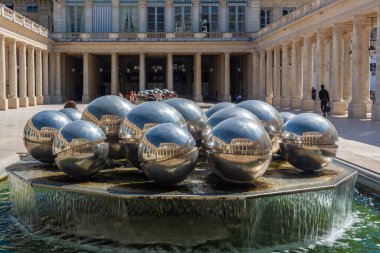 Paris, Fransa - 30 Ağustos 2019: Sephrades olarak bilinen gümüş toplar, güneşli bir günde Kraliyet Sarayı avlusunu yansıtıyor.
