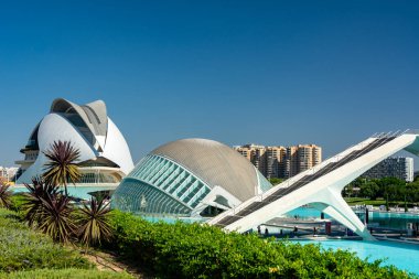 Valencia, İspanya - 12 Ağustos 2022: Açık mavi gökyüzü altındaki City of Arts ve Sciences 'taki turkuaz havuzlarda yansıyan L' Hemisferic ve Palau de les Arts 'ın dış görünüşü.
