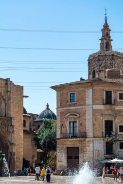 Valencia, İspanya - 12 Ağustos 2022: Turia Çeşmesi 'nden geçerek Valensiya Katedrali' nin mavi kartonlu kubbesine ve Plaza de la Virgen 'deki Gotik koro tezgahlarına doğru yürüyen ziyaretçiler.