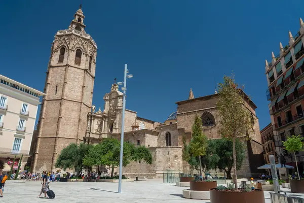 Valencia, İspanya - 12 Ağustos 2022: Valencia Katedrali 'nin yükselen çan kulesinin yan görüntüsü ve Turia Gardens' a bakan koyu mavi bir yaz gökyüzünün altındaki Barok cephesi
