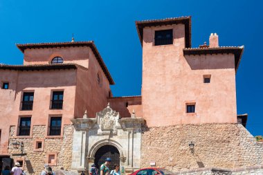 Albarakin, İspanya - 15 Ağustos 2022: Pastel mavi cepheli ve kırsal taş binalı günışığı ortaçağ sokağı, balkonlar ve kemerli pencerelerle çevrili dar kaldırım taşı yolu.