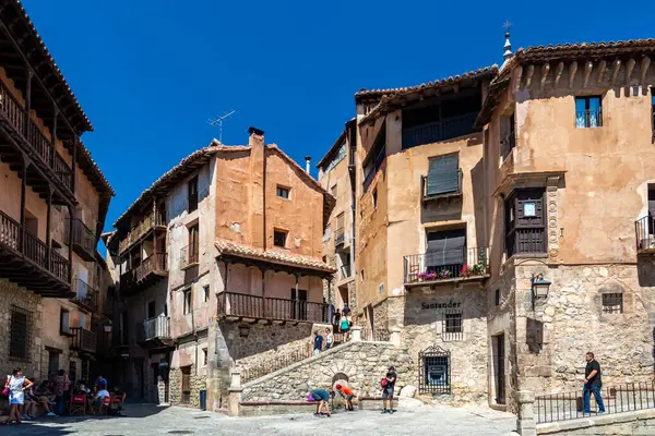 Albarakin, İspanya - 15 Ağustos 2022: Ziyaretçiler, terasotta yıkanmış evler ve ahşap balkonların arasında gezinerek açık bir gökyüzünün altındaki tarihi Plaza Belediye Başkanı 'na açılıyorlar..