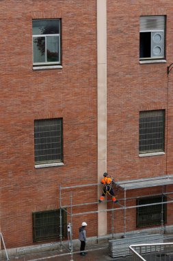 Bakım bir binada çalışıyor.