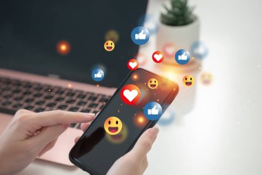 Cep telefonuyla çevrimiçi dijital iletişim bilgileri. Sosyal medya simgeleriyle akıllı telefon kullanan bir kadın. Bizimle ve sosyal medya konseptiyle bağlantı kur.