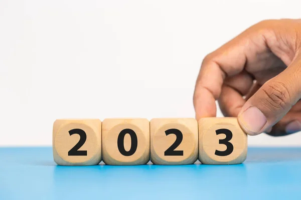 stock image Target start to year 2023 concept. Hand of man putting wooden cube block with goal icons year 2023.  copy space.