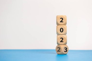 2022 sayılı odun blokları küpleri 2023 mavi arka plana geçer. Yeni yıl 2022 - 2023 konsepti.