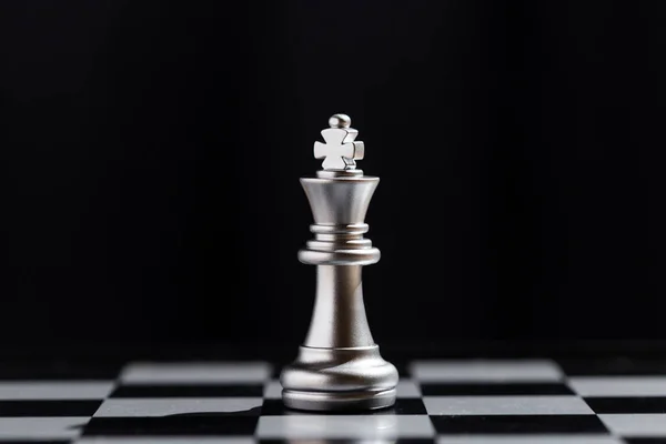 Close up silver king chess piece standing alone on board black background. strategic business leadership successful teamwork. business leader concept. strategy challenge business of successful.