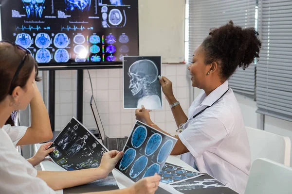 教室で医学を勉強しています X線フィルムから学ぶことにより 人間の脳疾患診断を学ぶ医学生 診断のための脳外科について学ぶ ストック写真