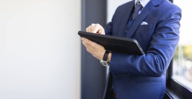 Ofiste dijital tablet ve touchpad bağlantı aygıtı kullanan işadamı.