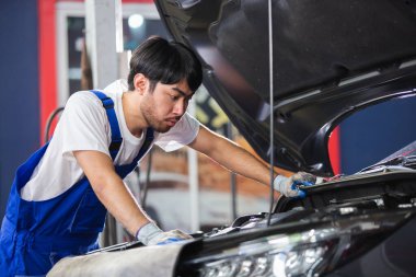 Ulaşım onarım servisi konsepti, Tamirci oto tamircisi motor içindeki hasarı kontrol ediyor. Erkek işçi servis motoru tamirhanesi.