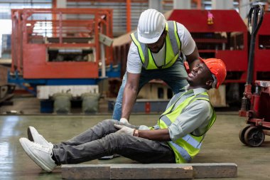 Industrial accident concept. Male african american accidents from working carrying heavy objects on legs in Industrial factory.