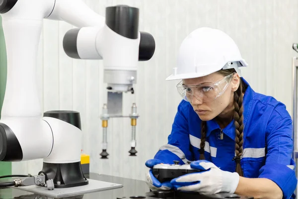 female technician engineer using remote control automation robotics at industrial modern factory. woman working at factory innovation automation robot.