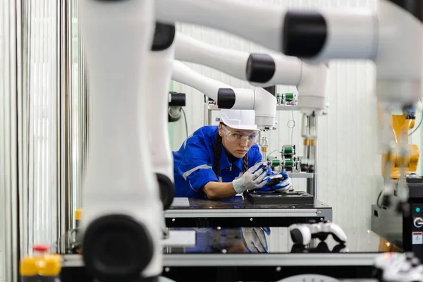 female technician engineer checking automation robotics at industrial modern factory. woman working at factory innovation automation robot.