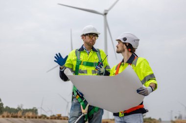 Ekip mühendisi rüzgar türbini yenilenebilir enerji güç rüzgarı üzerinde çalışıyor. teknoloji çevreyi korur küresel ısınma sorunlarını azaltır.