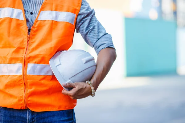 crop image, man engineer holding hard hat. Safety helmet used for work protection in industry.