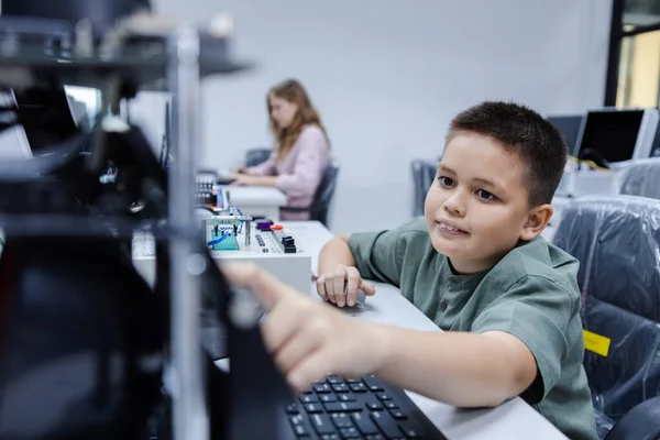 Boy in electronic class room. Kid boy education electronic AI class and touching screen STEAM digital. learning innovation electronic for future AI. electric system skill training. STEM education concept.