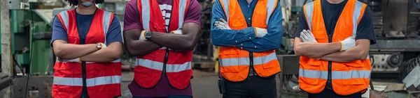 Crop image, engineer professional successful team corporate workers crossed arms standing in factory. teamwork technician inspector manufacturing industry workplace.