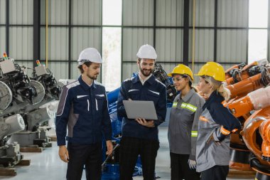 Robot montaj fabrikasında çalışan mühendisler konuşuyor, toplanıyor, durum denetimi kalitesinde robot kolu inceliyorlar. Takım çalışması teknisyeni robotik endüstriyel.