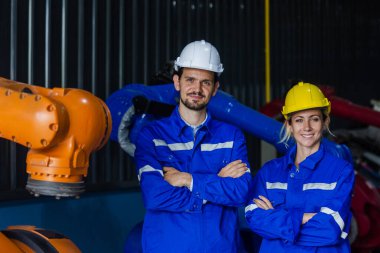 Portre mühendisi ve kadın mühendis robot fabrikasında üniforma giyiyor. Ekip mühendisliği teknisyeni, atölye çalışması, grup teknisyeni endüstriyel.