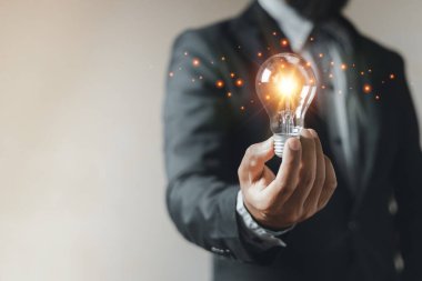 Fikir yeniliği kavramı, elinde ampul tutan adam aydınlandı. Yaratıcı enerji öğrenme dehası. Düşünce ve yaratıcılık.