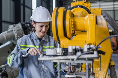 Mühendis kadın ingiliz anahtarı bakım robotu kolu kullanıyor. Kadın teknisyen endüstriyel kontrol robotu. Gelecekçi sanayi üretimi.