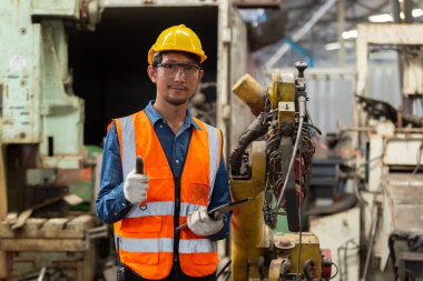 Üniforma giyen Asyalı mühendis güvenlik ve sıkı şapka takan işçi fabrika endüstrisinde metal torna, işçi manufactory endüstrisi konsepti. Atölyedeki tamirci..