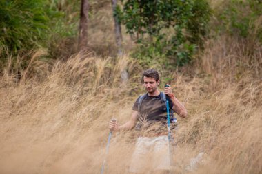 Beyaz adam altın çimenlerde tek başına yürüyor sırt çantasıyla yürüyüş yapıyor, önünde hedefler arıyor. Yürüyüş turu, gelecekteki zorluklar konseptiyle yüzleşmek.