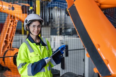 Kadın teknisyen modern fabrika, robot operasyon bölümünün teknik danışmanı. Mühendis, tablet kontrol robotik otomatik, Fabrika Endüstrisi otomatik sistem yazılımı kullanıyor.
