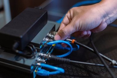 Erkek el işi, kablo SDI ve HDMI 'yi kablosuz video vericisi ve alıcı sistemine bağlıyor. Televizyon stüdyosu canlı yayında. ortam üretimi.