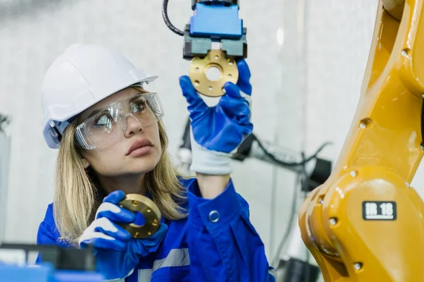 Female technician engineer robotics working at industrial modern factory. woman working at factory innovation automation robot. Staff introduces operation of robots in production process.