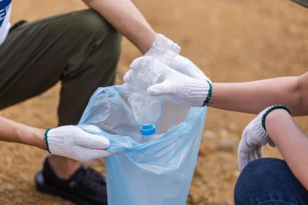 Close Mão Segurando Garrafa Plástico Colocar Saco Lixo Grupo Jovens — Fotografia de Stock