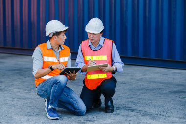 Ekip mühendisliği ustabaşı, Asyalı ustabaşı elinde klasör ve tablet mühendisliği ile ithalat için konteynır yükleme konteynırı, endüstriyel konteynır konteynır konsepti..